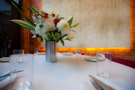 Table set with flowers and rug in background.