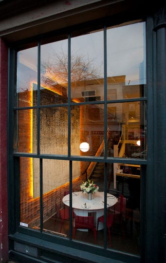 Window of Greek Gastown looking into restaurant.