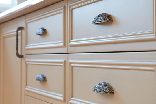 Stunning metallic handles on wooden drawers in luxury, personalized kitchen.