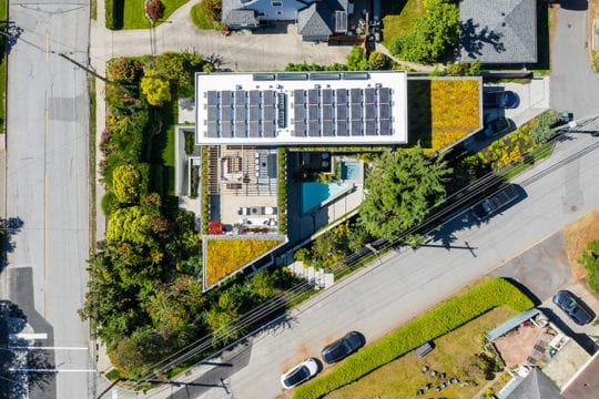 Aerial view of upper patio and deck with custom trellis, solar panels and green roof