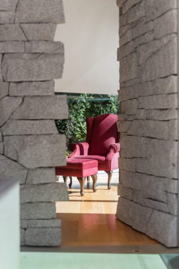 Stone brick columns on hardwood flooring in front of living space.