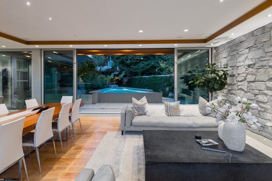 Custom living room with hardwood flooring and stone wall in North Vancouver custom home.