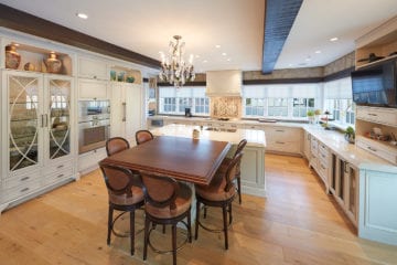 Full view of custom kitchen with several windows and an abundance of cupboard and counter space.
