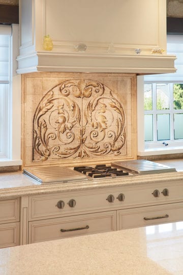 Hand painted backsplash between stovetop and stove fan